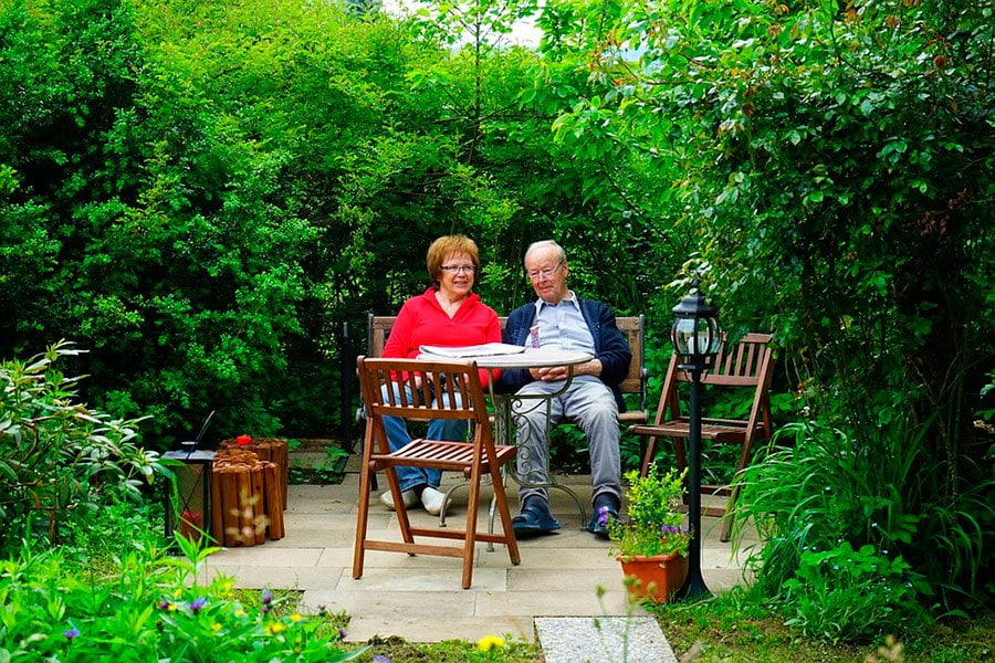 esta pareja disfruta de un agradable dia sentados en su jardin.
