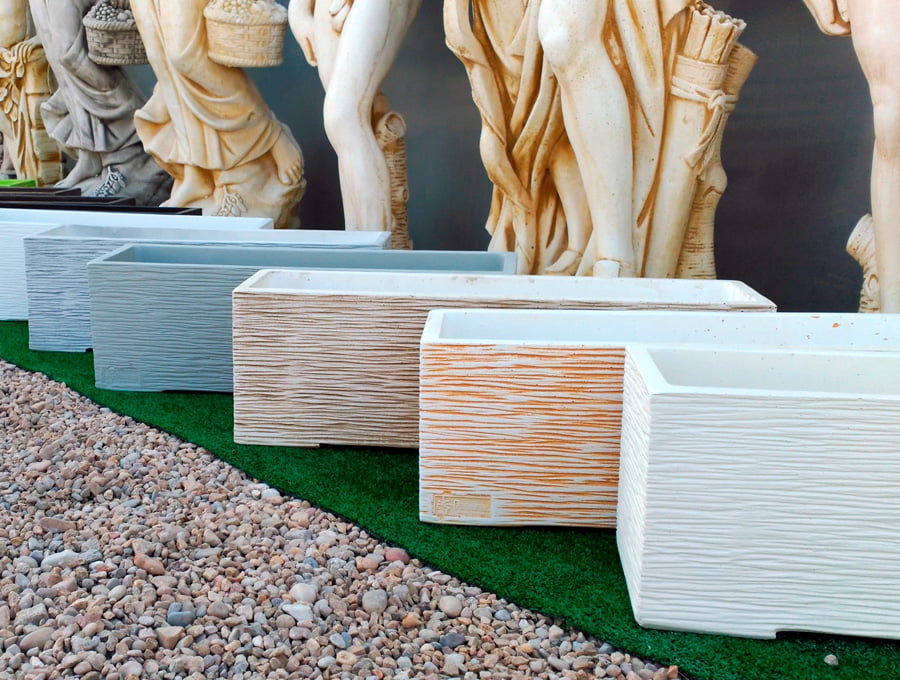 Exposición con distintas jardineras grandes rectangulares de piedra artificial. Diponibles en distintos colores e imitaciones.